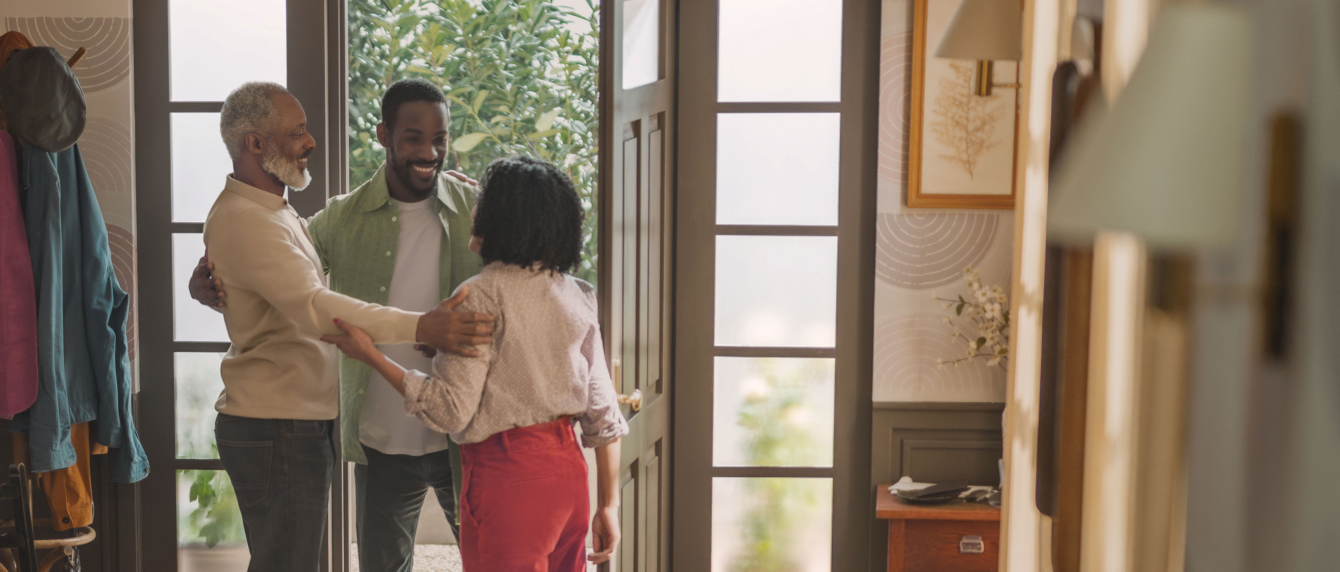 Man greeting his family in the doorway of his home
